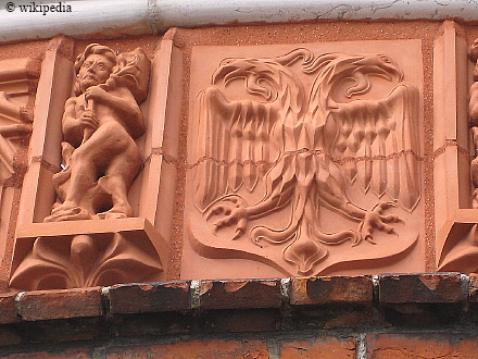 Holstentor Lübeck - erneuerte Terrakottaplatte an der Außenfassade    -  Für eine größere Darstellung auf das Bild klicken.